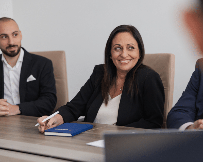 Sarah Hull, A2CO's client onboarding officer attending a meeting with the A2CO Compliance Department, with Albert Block in the background.
