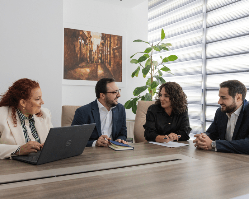 A2CO's Tax team including Partner Antoinette Scerri, Benjamin Zammit McKeon, Stephanie Bianco and Clivert Vella posing for a during a meeting.
